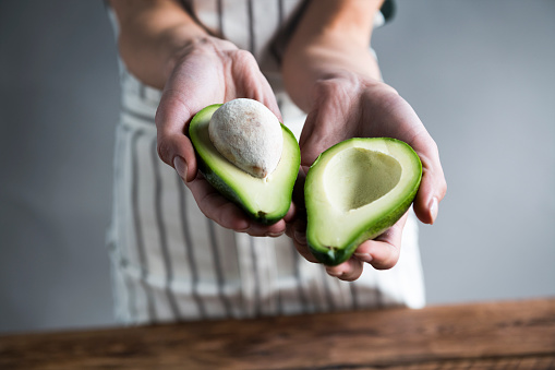 woman holding avocado