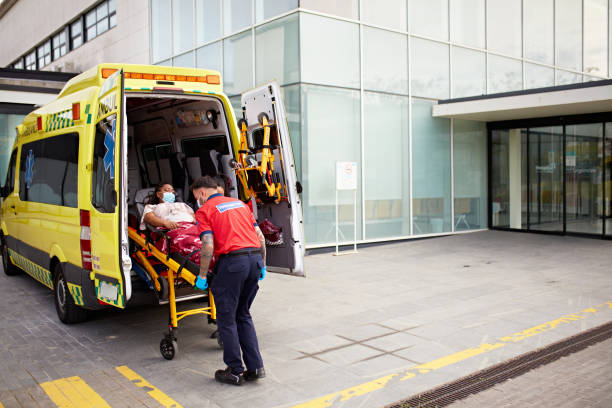 Paramedic team removing portable stretcher from ambulance stock photo