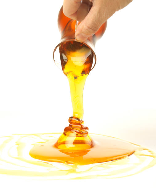 istock Pouring golden honey on a white background 1485770904