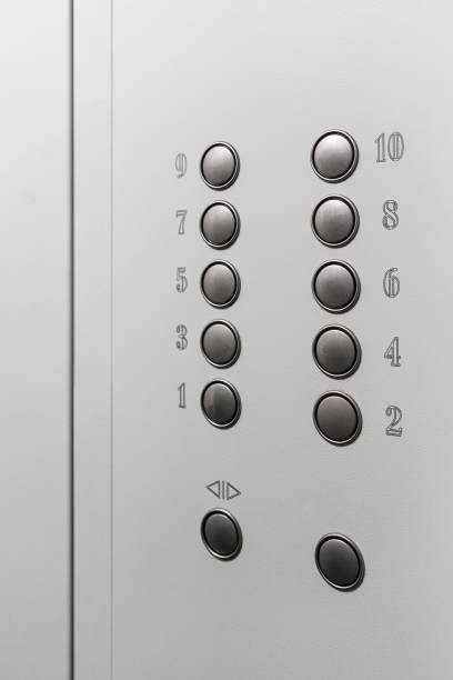 Gray elevator panel with silver buttons in a ten-story building stock photo