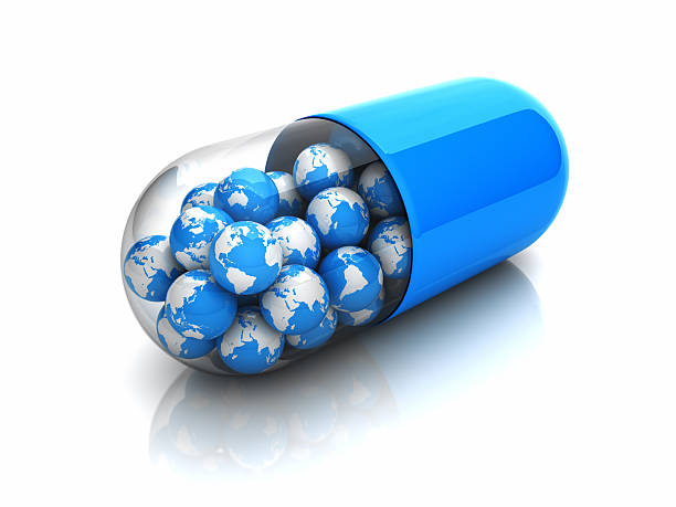 A pill capsule filled with miniature earths Blue globes in drug capsule big pharma stock pictures, royalty-free photos & images