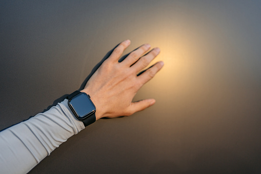 Fitness tracker on a young man's hand outdoors.