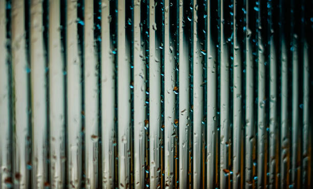 istock Window glass surface with a strip pattern in the rain. Shot in close up with selective focus. Great for background and pattern designs. 1485777250