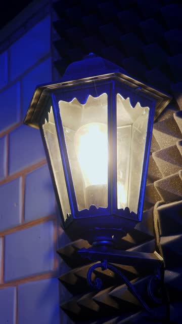 Switching on lantern lamp with light warm light. Vertical video. Vintage lantern