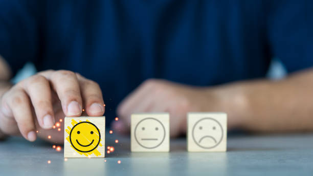 istock A customer hand chooses a happy face on a wood block cube from three faces. 1485781705
