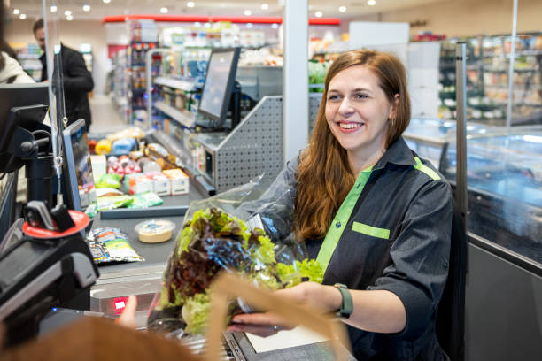 istock Supermarket Clerk Smiling While Working At Checkout 1485785316