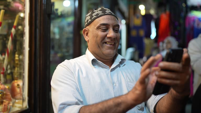 Mature man using smartphone in local market