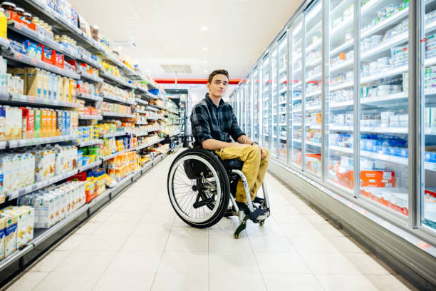 Porträt eines Mannes im Rollstuhl im Supermarktgang – Foto