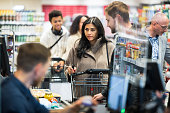Customers Queuing At Checkout In Local Supermarket