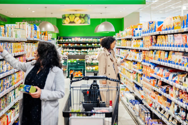 Customers Browsing Products Down Supermarket Aisle - fotografia de stock