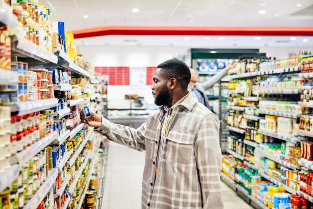 istock Man Selecting Product From Shelf While Looking For Groceries In Supermarket 1485787436