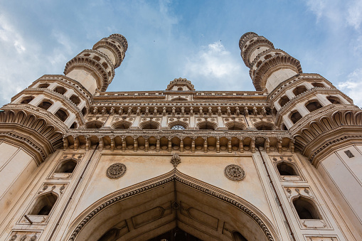 Minarets of Charminar in Hyderabad. The fifth ruler of the Qutb Shahi dynasty, Muhammad Quli Qutb Shah, built the Charminar in 1591. The Charminar masjid is a square structure with each side being 20 metres (66 ft) long. Each of the four sides has one of four grand arches, each facing a fundamental point that opens directly onto the street in front of it. At each corner stands an exquisitely shaped 56 metres (184 ft) high minaret, with a double balcony. Each minaret is crowned by a bulbous dome with dainty, petal-like designs at the base. Charminar's four fluted minarets are built into the main structure. There are 149 winding steps to reach the upper floor. The structure is also known for its profusion of stucco decorations and the arrangement of balustrades and balconies.