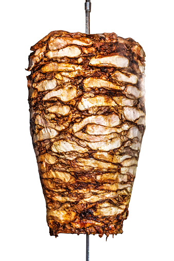 Delicious Turkish Doner kebab isolated on white background. Rolling meat doner in iron stick.