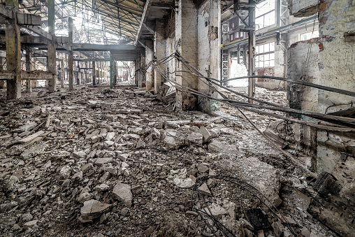 Industrial abandoned interior. Ruins of old factory. High voltage cables on the wall