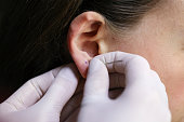 Young woman puncturing her ear