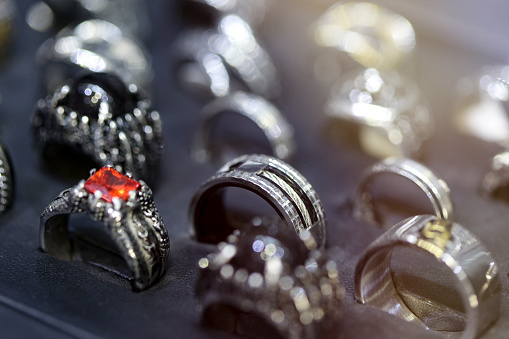 Selection of silver and steel rings in a jewelry store display.