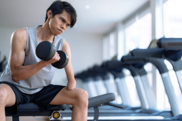 istock Asian man with disabilities exercising by lifting dumbbells. 1485796287