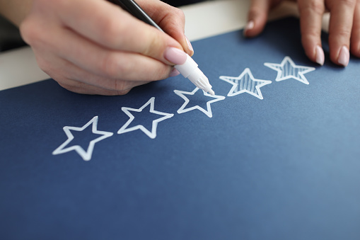 Person paints over star with marker on review. Recommendation rate us and customer feedback