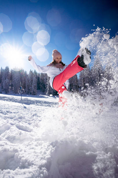 Carefree teenage girl playing whit snow on mountain stock photo
