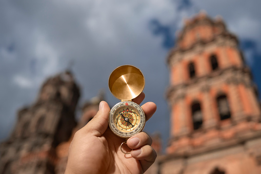 hand with compass with the metropolitan cathedral of san luis potosi in the background