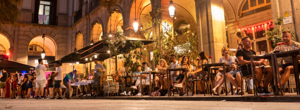 Plaça Reial square panorama in Barri Gotic off La Rambla in Barcelona Catalonia Spain Barcelona, Spain - June 17, 2022:  Plaça Reial or Royal Plaza is a public square with an ornate fountain and palm trees in the Gothic Quarter off of La Rambla in Barcelona Catalonia Spain.  It is a popular tourist attraction at night with many restaurants and nightclubs barcelona province stock pictures, royalty-free photos & images