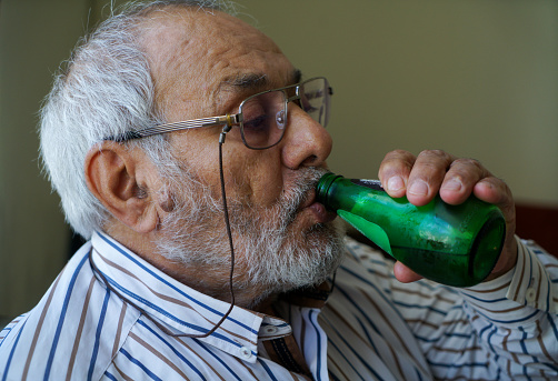 Senior man drinking bottled water