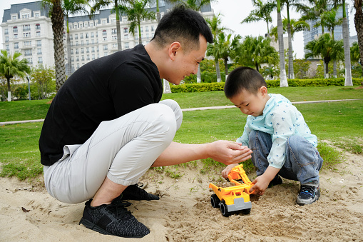 Father and son playing together on the beach