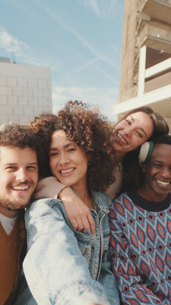istock Happy smiling friends make a video call from a mobile phone. Four students wave their hands in greeting 1485808865