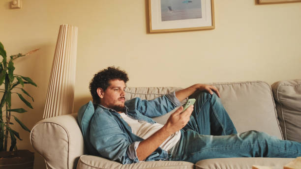 istock Happy guy holds smartphone in his hands, sends text message, communicates in social networks, surfs the web while sitting indoors 1485808901