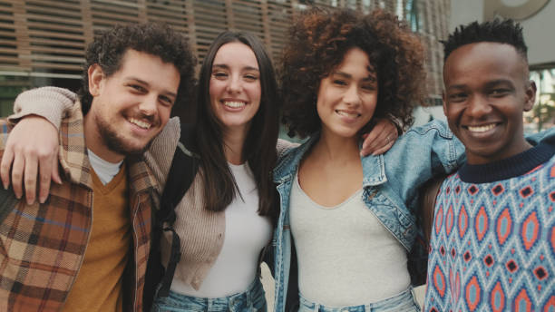 istock Close up, young smiling people posing while standing on the street. Four students look at the camera and smile. 1485809156