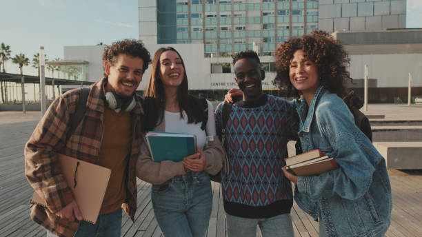 istock Young cheerful people pose for the camera. Group of students smiling while looking at camera while standing outside 1485809195