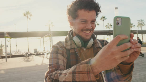 istock Smiling guy taking a photo on a mobile phone while standing on the street 1485809239