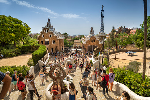 Barcelona, Spain - June 14, 2022:  Summer tourist crowd gathers in Park Guell designed by artist and architect Antoni Gaudi in Barcelona Catalonia Spain