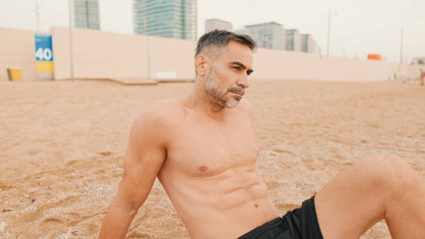 istock Middle aged muscular man sitting relaxed on the beach 1485810652