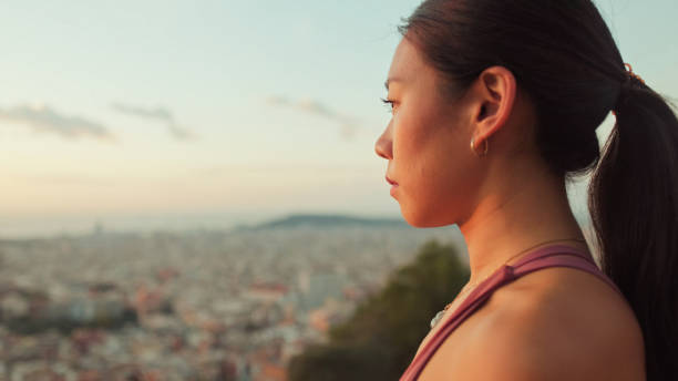 istock Close-up of girl meditating while sitting on viewing platform at dawn 1485811085