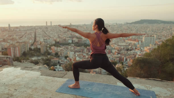 istock Young woman practices yoga at sunrise on viewing platform 1485811244
