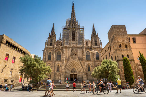 Tourists walk by the Cathedral of Barcelona in Spain stock photo