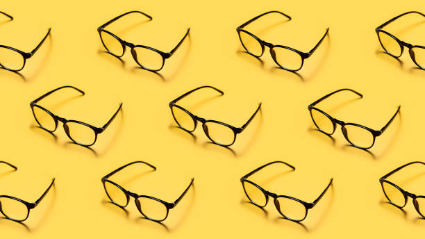 Modern black framed reading glasses or spectacles repeated on a bright yellow background with minimalist style. Modern black framed reading glasses or spectacles repeated on a bright yellow background with minimalist style. reading glasses stock pictures, royalty-free photos & images