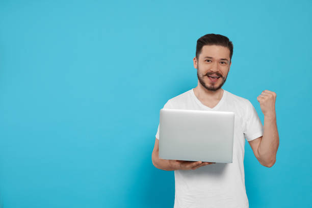 istock Happy man with laptop on light blue background. Space for text 1485823849