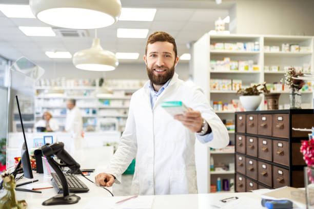 istock Young Man Pharmacist smiling showing a medicine looking at camera 1485832912