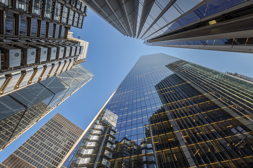 Abstract pattern of skyscrapers windows with reflections of blue sky and other business buildings. Abstract corporate business or architecture background.