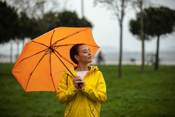 istock Girl with an orange umbrella is walks in the spring. 1485836721