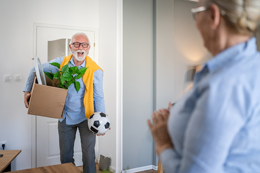 family senior couple man woman husband and wife pensioner grandfather grandmother moving in new apartment taking their stuff belongings and plants in or out of boxes packing or unpacking real people