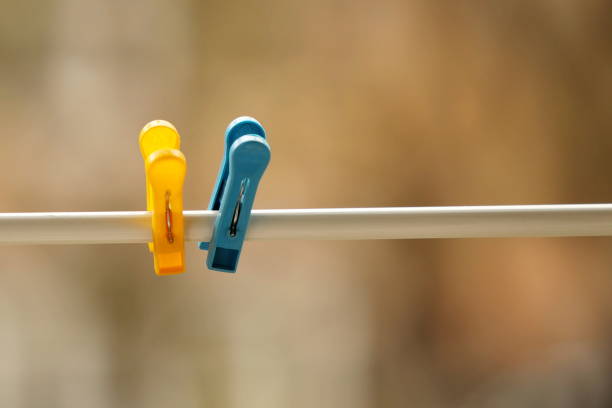 istock Two blue and yellow clothespins on a rope. 1485839886