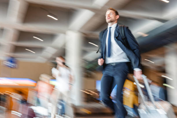 istock Young Business Man Wearing A Suit And Running Towards The Exit While Pulling His Suitcase 1485841842