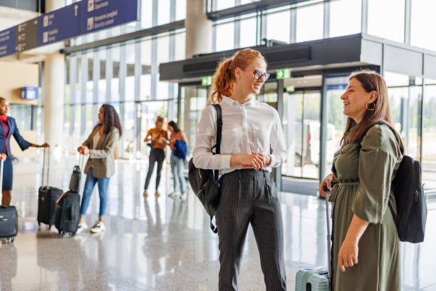 istock Two Female Colleagues Standing And Talking Together While Waiting To Make The Check-In For Their Flight 1485841911