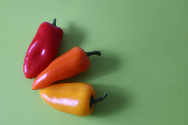 istock Various color of paprikas isolated on a green background. 1485843439