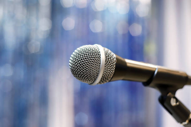 istock Microphone on the stage against the blurred blue tinsel background 1485844367