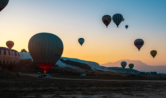 A Serene Sunrise at Pamukkale National Park with Hot Air Balloons in Sight