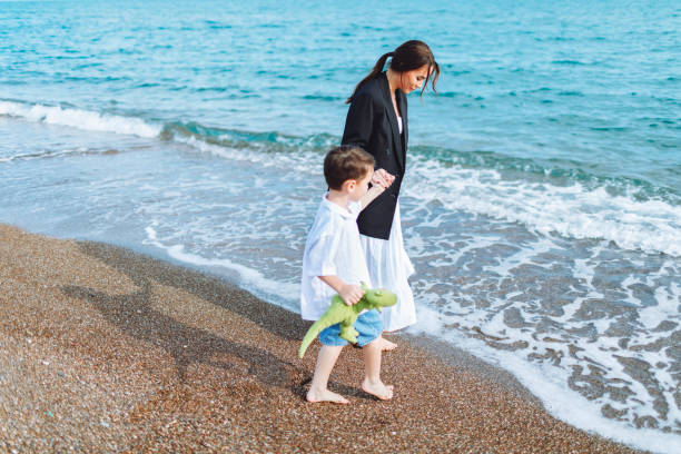 istock Mother and son walking at the beach and having fun 1485845003